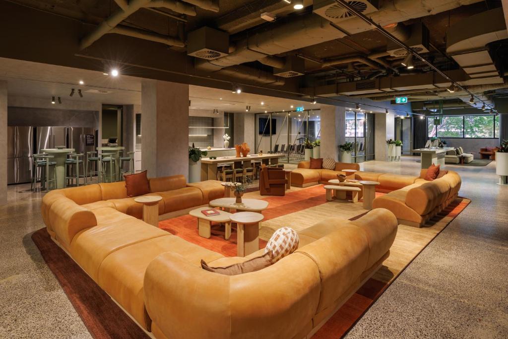 a large living room with a large couch and tables at lyf on Elizabeth Melbourne in Melbourne