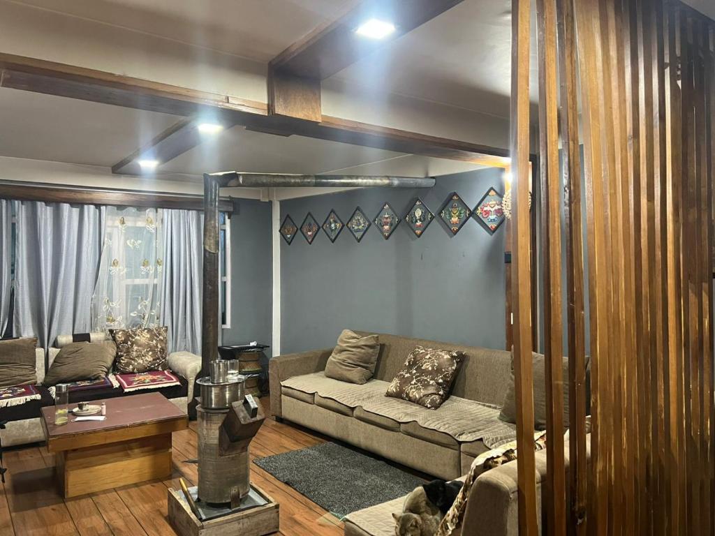 a living room with a couch and a table at Maitreya Homestay in Tawang