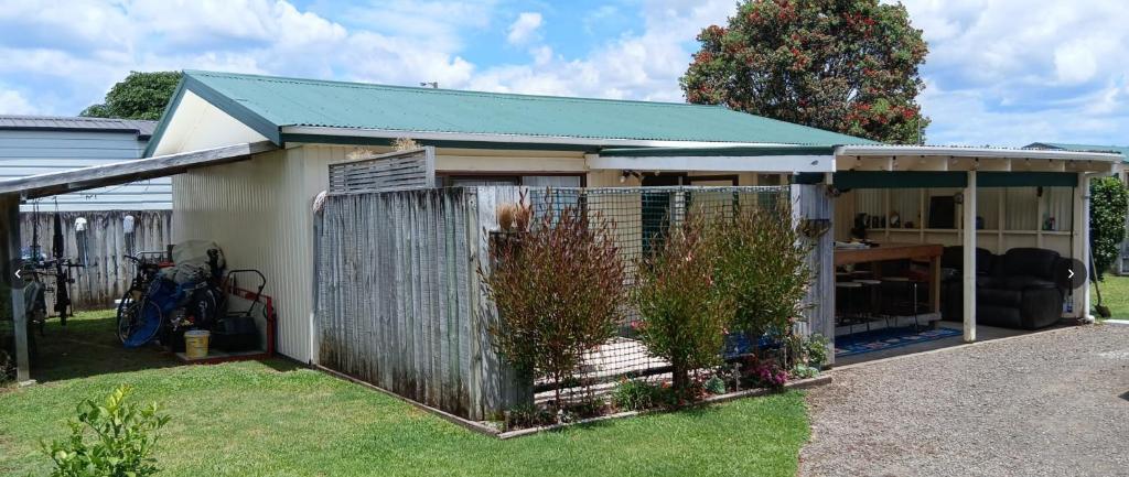een huis met een hek in de tuin bij Hosts on the Coast Sandy Paws in Whitianga