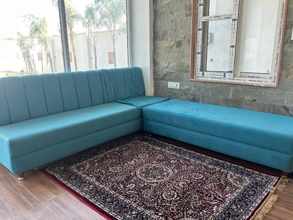 een blauwe bank in een kamer met een tapijt bij Mangal Uday Villa in Jaipur