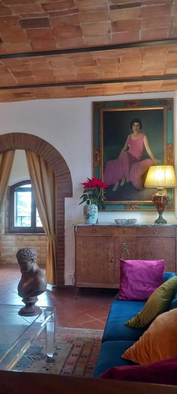 een woonkamer met een bank en een schilderij aan de muur bij Vita Toscana Guest House in Chiusi