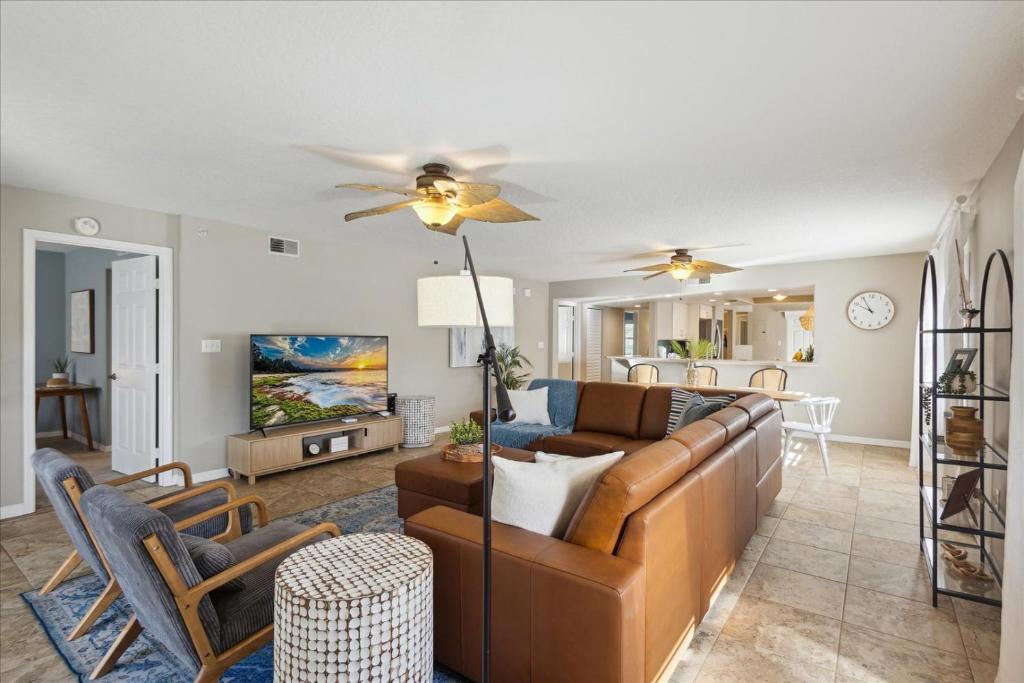 a living room with a couch and a ceiling fan at Shorewood 401 in Cape Canaveral