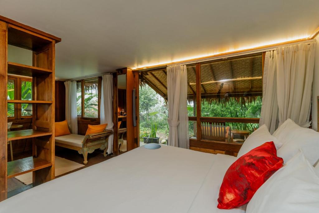 a bedroom with a large white bed and a window at Tira Vilagna Suites & Spa in Kintamani