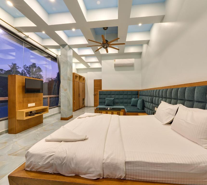 a bedroom with a large bed and a tv at Natural resort in Panhāla