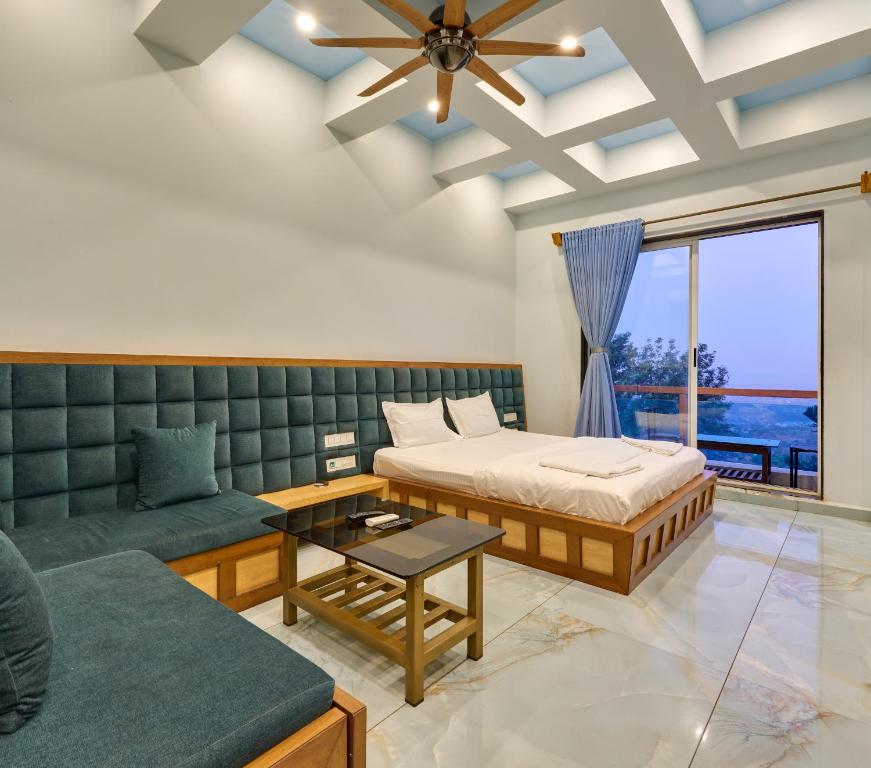ein Schlafzimmer mit einem Bett, einer Couch und einem Tisch in der Unterkunft Natural resort in Panhāla
