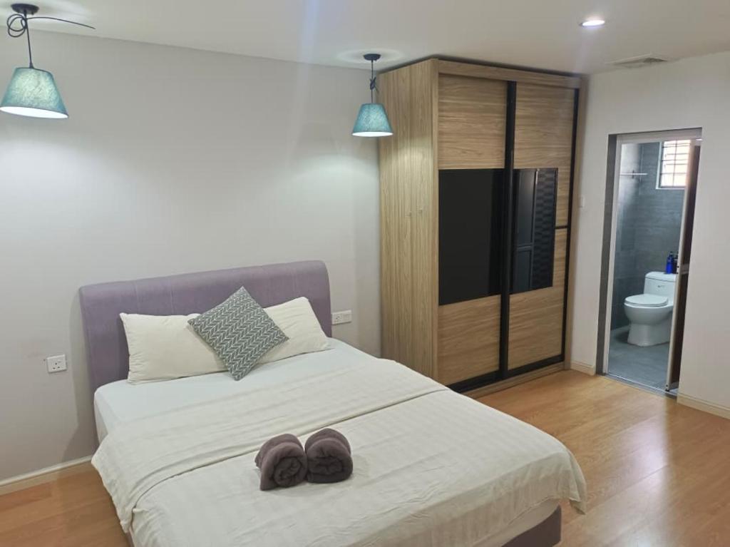 een slaapkamer met een bed met twee slippers erop bij Nordic Residences in Melaka