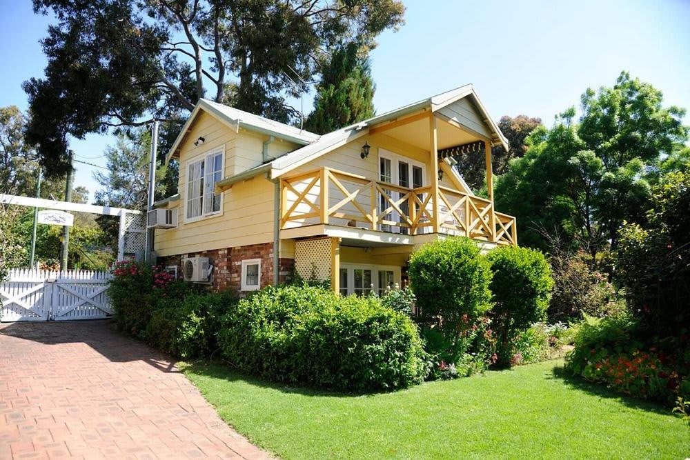 a large yellow house with a gambrel at Banksia Cottage in Perth Hills in Perth