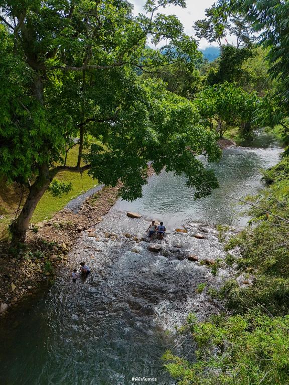 a group of people swimming in a river at กู๊ดวิวแคมป์ชะอม in Ban Bung Mai