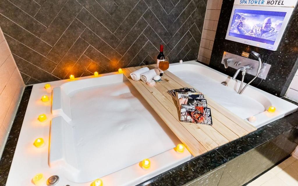 a bathtub with candles and a bottle of wine at Spa Tower Motel in Daejeon