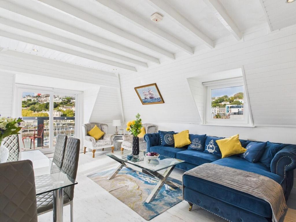 een woonkamer met een blauwe bank en een tafel bij The Boathouse in Torquay