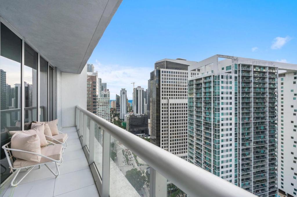 a balcony with a chair and views of the city at Brickell 35th Floor Residence with Saltwater Pool 5-Star Amenities in Miami