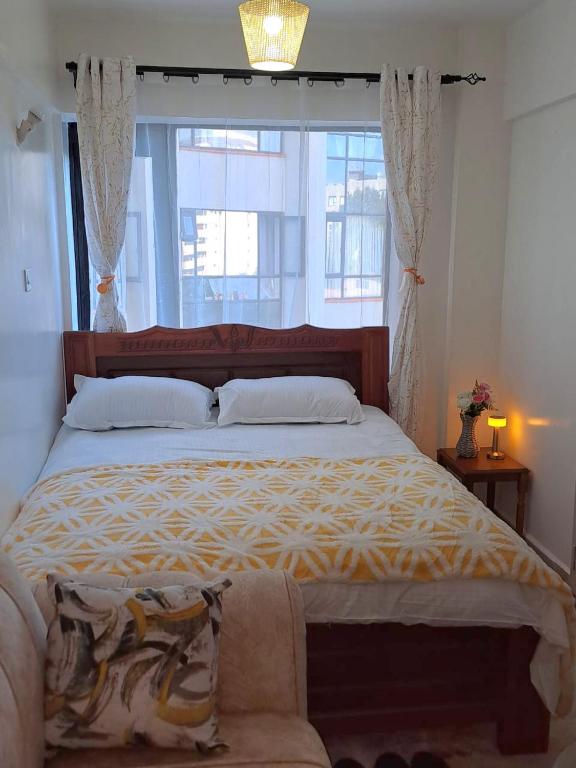 a bedroom with a large bed with a large window at The cozy nook - Thindigua in Kiambu