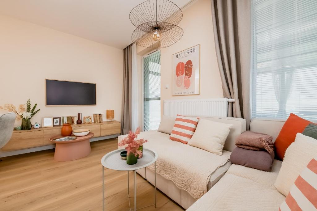 un soggiorno con un divano e una TV di Matisse Apartment a Białystok