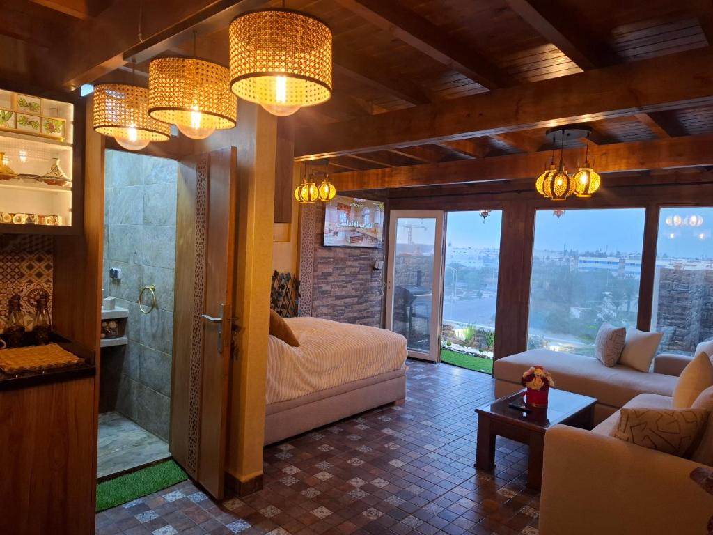 een woonkamer met een bed en een glazen douche bij Rooftop studio with ocean view in Essaouira