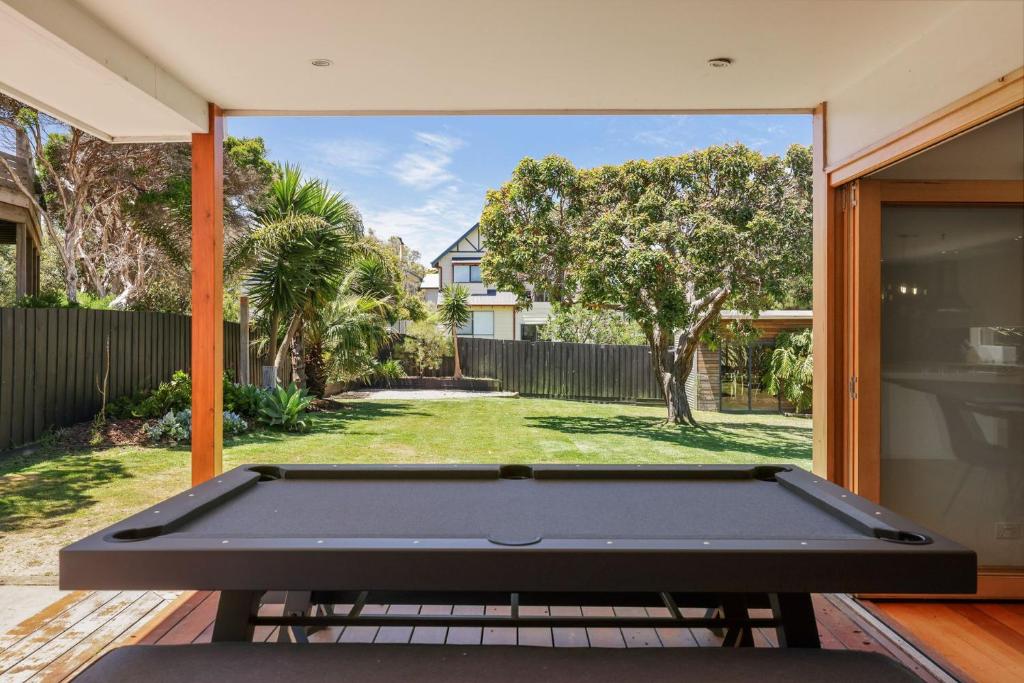 een biljarttafel op een terras met uitzicht op een tuin bij Barramundi Beach House in Smiths Beach