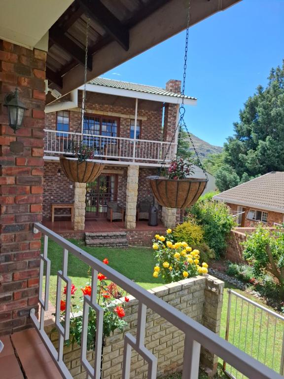 a house with a balcony with two flower pots at Sanchen's in Clarens