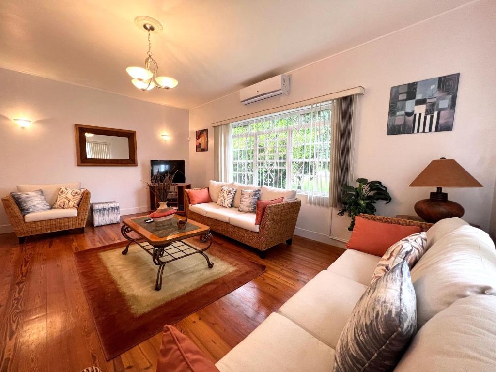 een woonkamer met twee banken en een tafel bij Tender Bay Beach Houses - by ZenBreak in Saint James