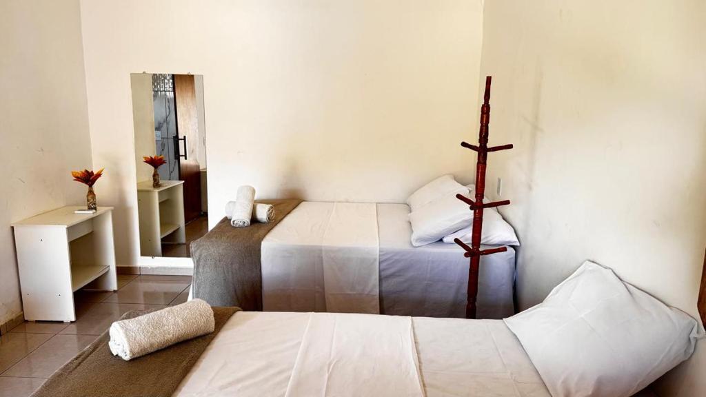 Zimmer mit 2 Betten und einem Kreuz an der Wand in der Unterkunft Pousada na serra da capivara in Coronel José Diaz