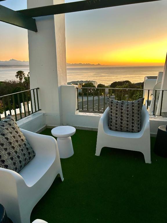 a balcony with a view of the ocean at sunset at Kana Vista in Plettenberg Bay