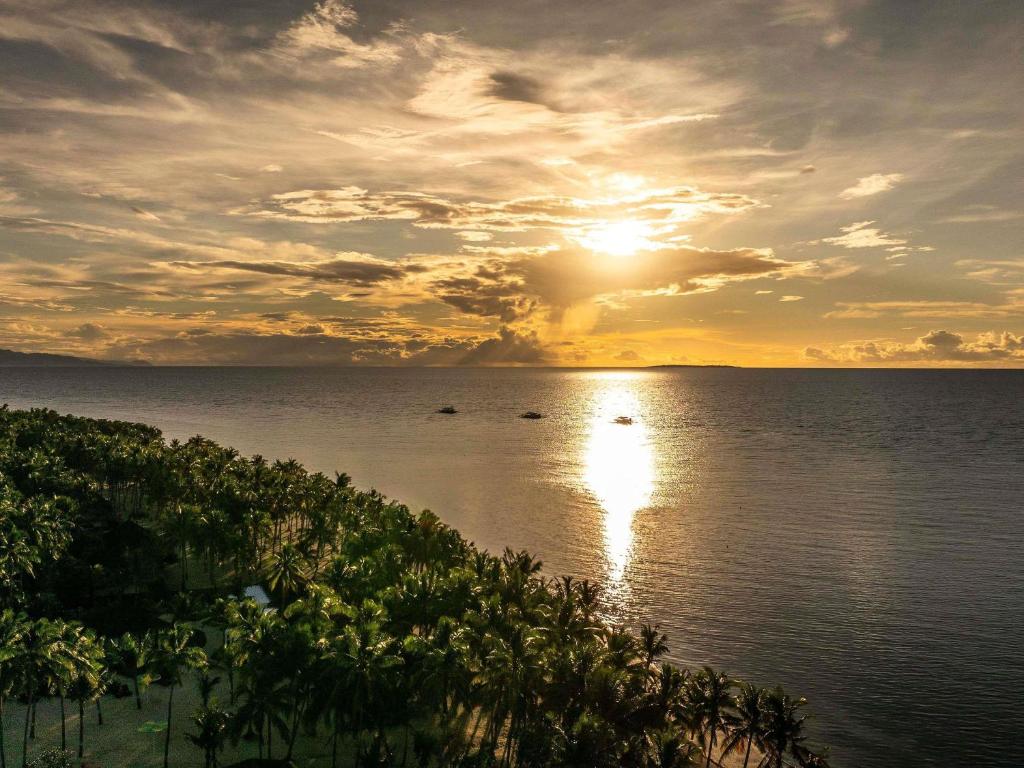 a sunset over the ocean with the sun setting at South Palms Resort and Spa Panglao - MGallery Collection in Panglao