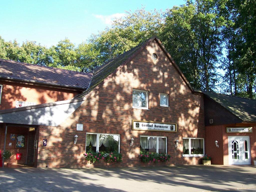 ein großes Backsteingebäude mit Bäumen im Hintergrund in der Unterkunft Hotel-Gasthaus Burmester in Heidenau