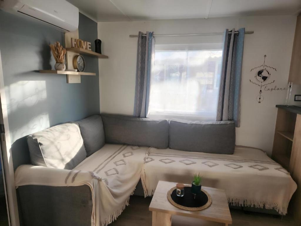 ein Wohnzimmer mit Sofa und Tisch in der Unterkunft Camping Siblu Bella Vita in Canet-en-Roussillon