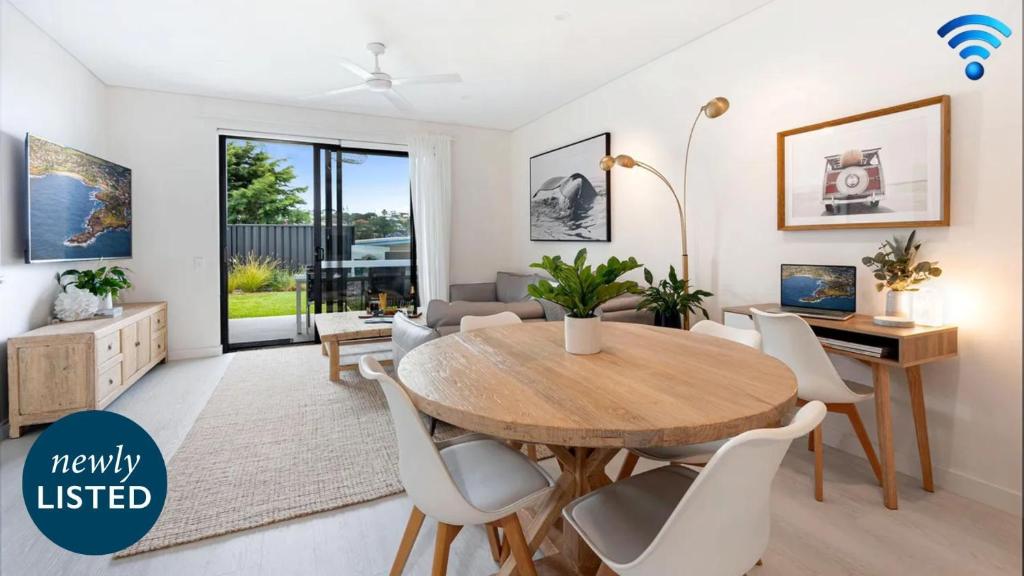 Una sala de estar con una mesa y sillas de madera. en Sunrise Ocean View, en Kiama