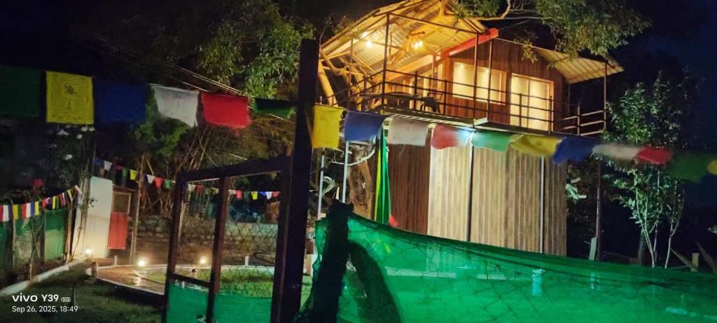 ein Zaun mit Gebetsfahnen und ein Haus bei Nacht in der Unterkunft Wild Ni8 Club 