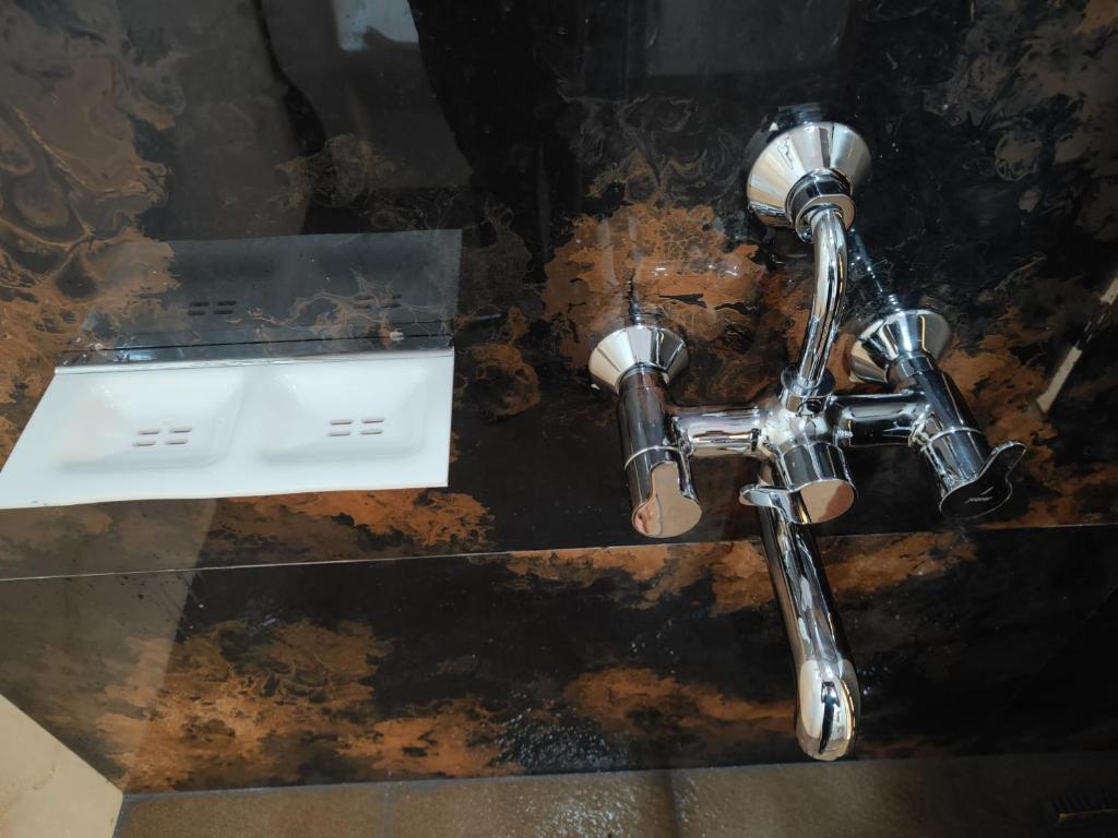 ein Badezimmer mit Waschbecken und Spiegel in der Unterkunft Nisarga Comforts in Chikmagalur