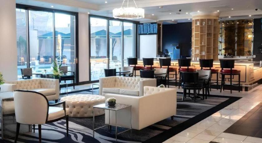 um átrio do hotel com mesas e cadeiras e um bar em Ahern Hotel and Event Center em Las Vegas
