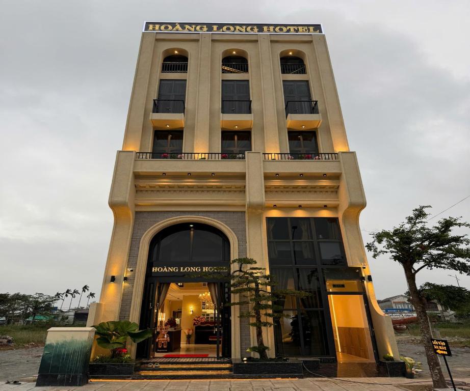 a large building with a sign on top of it at Hoang Long Hotel in Mộ Ðức