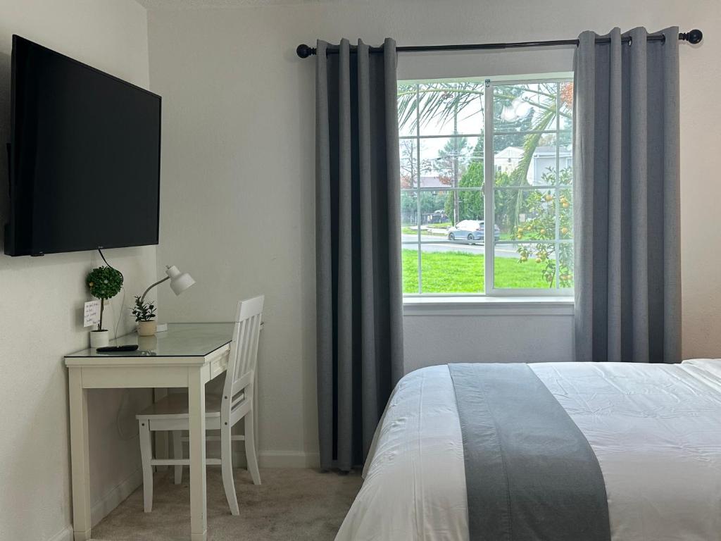 a bedroom with a bed and a desk and a window at Kitchen Suite A in Sacramento