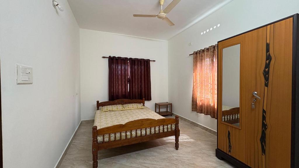 une chambre avec un lit et un ventilateur de plafond dans l'établissement Budget Non AC Room beside Kolencherry MOSC Hospital, à Kadayirippu