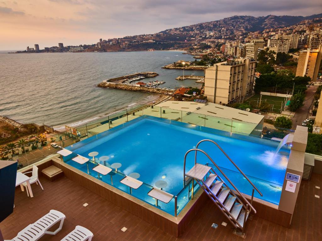 a swimming pool with a view of the water at Princessa Hotel in Jounieh