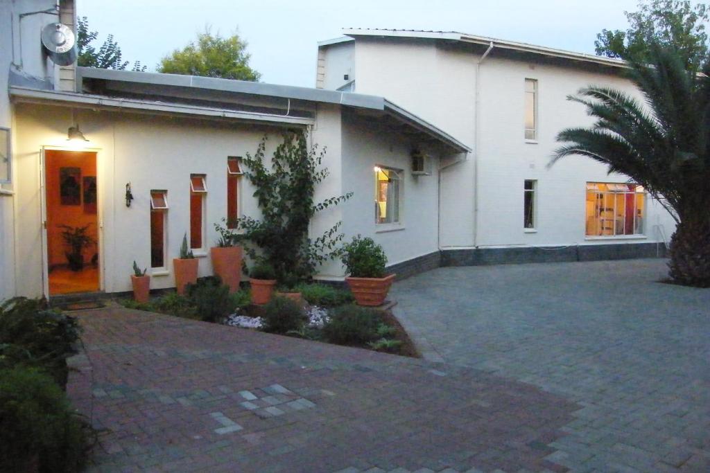 una casa bianca con un cortile di fronte di Hanekraai B&B a Vryburg