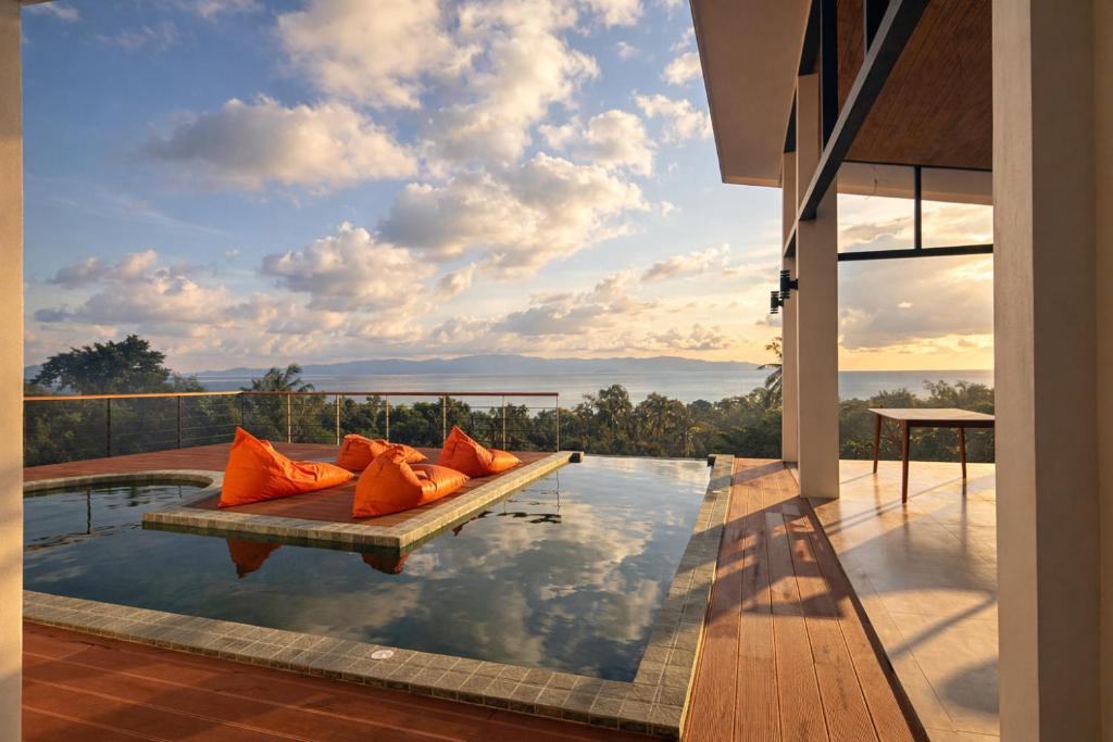 une piscine avec des coussins orange posée sur une maison dans l'établissement NAHA Villa Sea View Koh Phangan, à Baan Tai