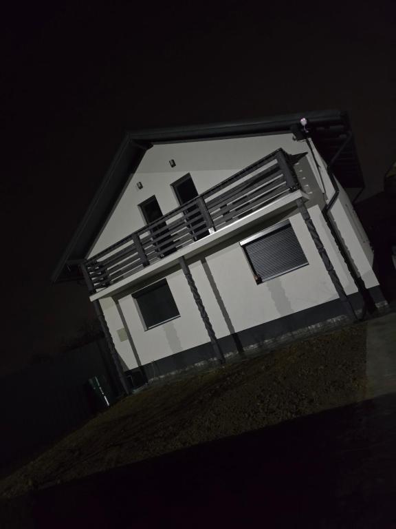 un edificio bianco con balcone di notte di Casa Valy a Buşag