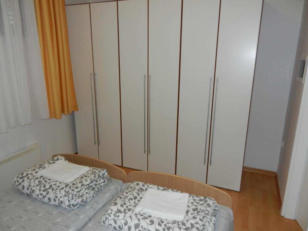 1 dormitorio con 2 camas y armarios blancos en Apartment Riba, en Ankaran