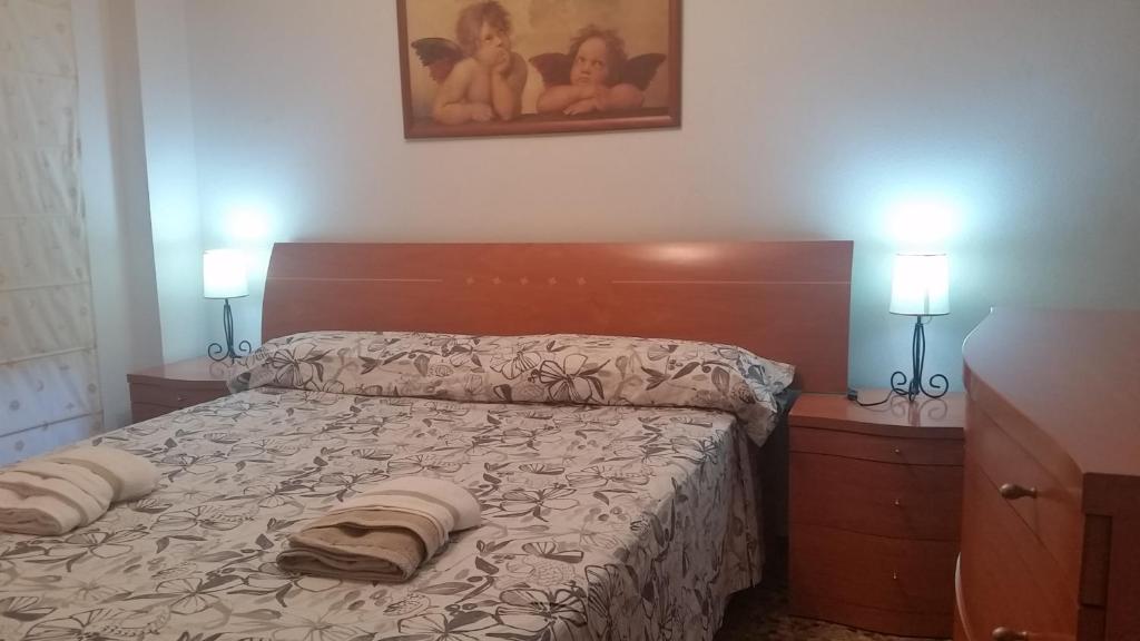 バレンシアにあるPasarela Apartmentのベッドルーム1室(ランプ2つ、枕2つ付)