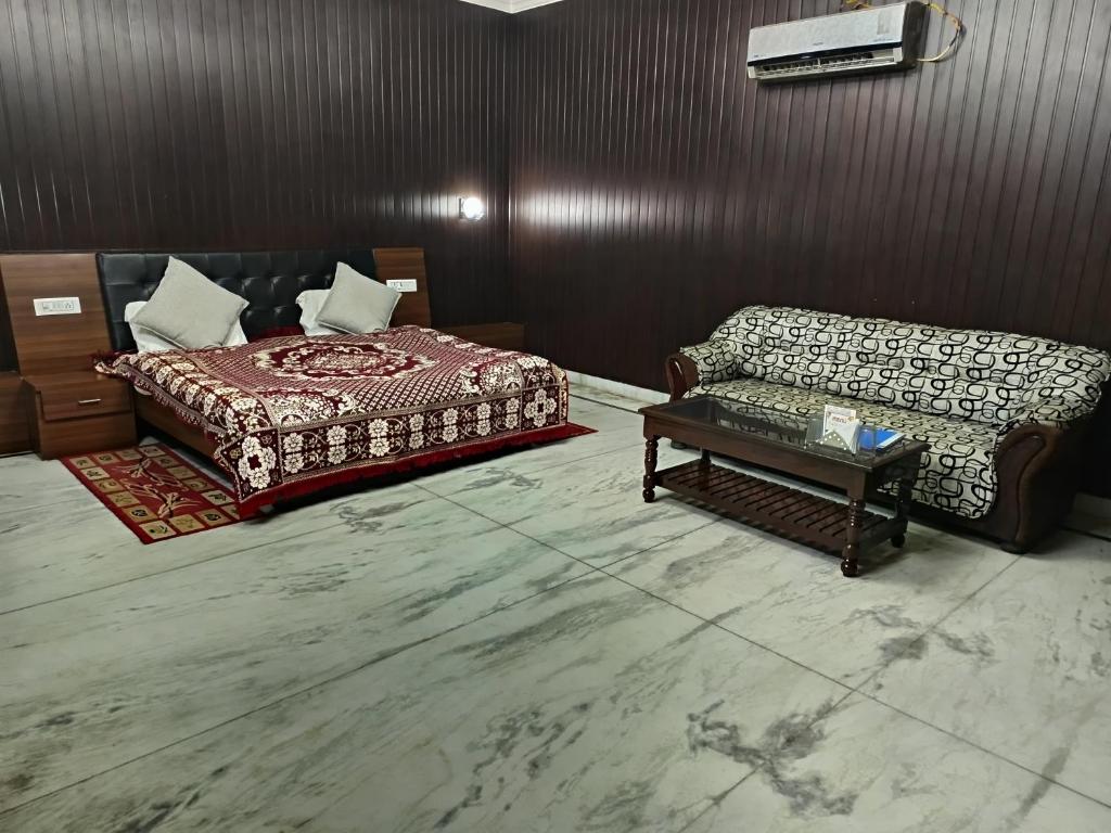 een kamer met een bed, een bank en een tafel bij Satkar palace hotel 
