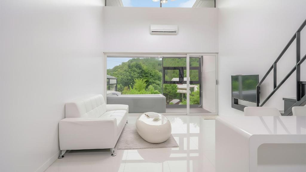 een witte woonkamer met witte meubels en een raam bij Gapyeong Shiny Pension in Gapyeong