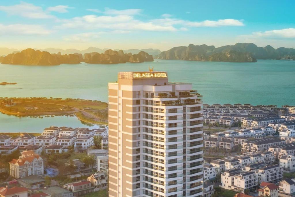 an aerial view of a tall building in front of a body of water at DeLaSea Ha Long Hotel - Modern Bayview Escape in Ha Long