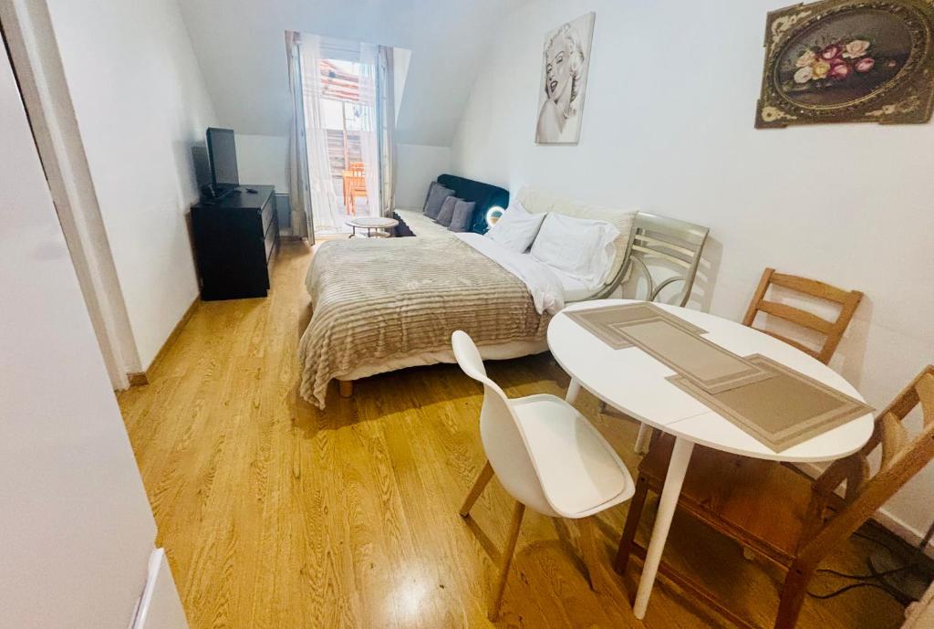 ein Schlafzimmer mit einem Bett, einem Tisch und einem Schreibtisch in der Unterkunft Appartement avec terrasse in Drancy