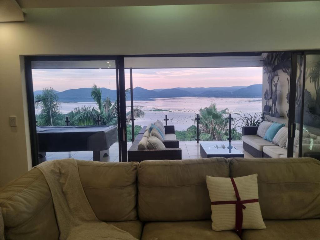 een woonkamer met een bank en uitzicht op de oceaan bij Mi Casa in Hartbeespoort