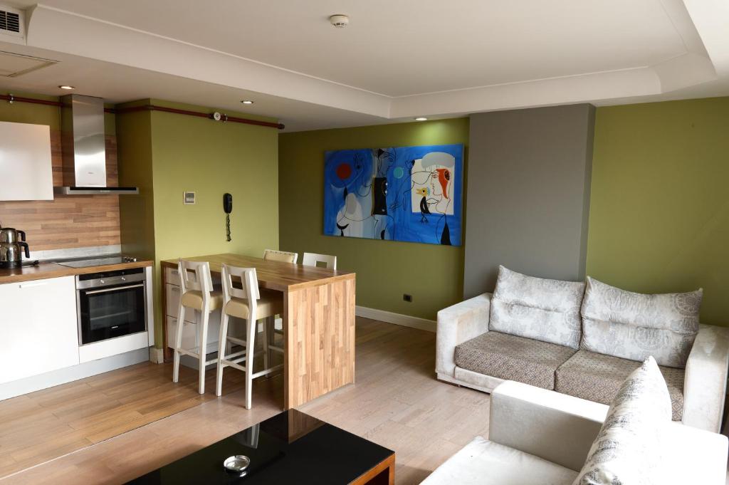 een keuken en een woonkamer met een bank en een tafel bij Taba Luxury Suites and Hotel in Istanbul