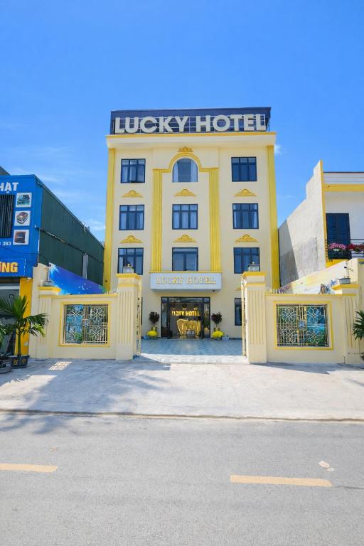 a large yellow building with a hotel sign on it at Lucky Hotel Uông Bí in Uông Bí