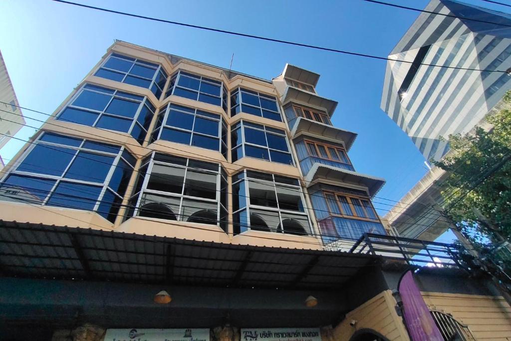 ein hohes Gebäude mit vielen Fenstern darauf in der Unterkunft Pratunam Family House in Ban Nong Chaeng