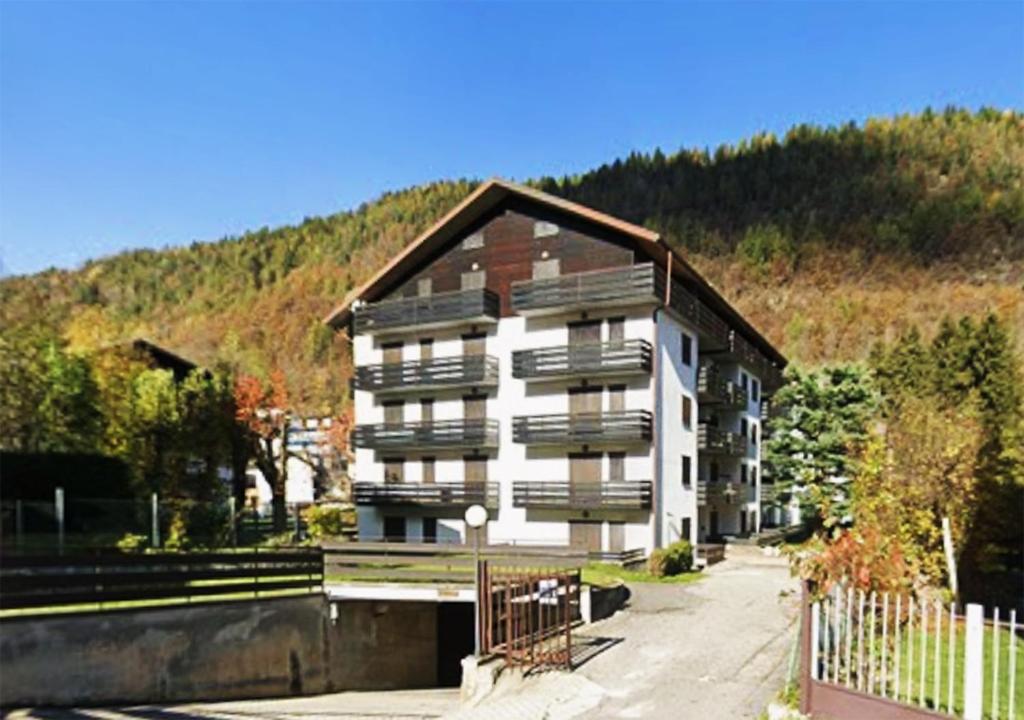 a large apartment building in front of a mountain at Appartamento Cedro - Centro Aprica - Park - WiFi in Aprica