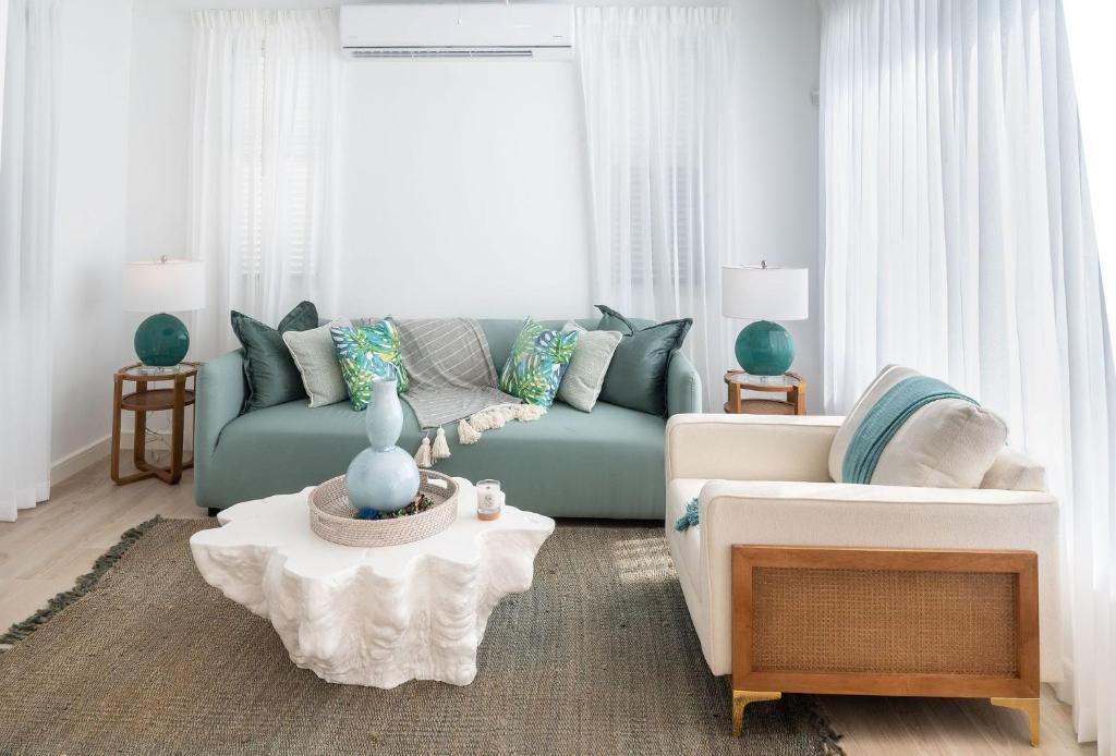 a living room with a blue couch and a table at The Nest Garden Grove - by ZenBreak in Saint James