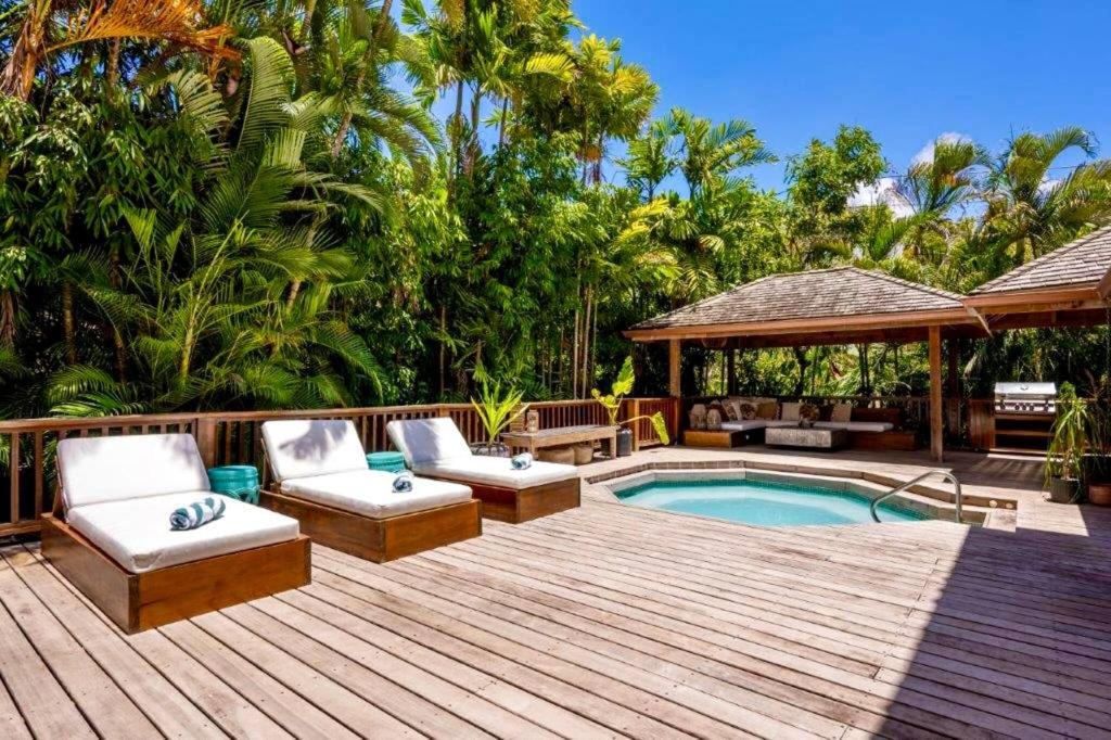 a deck with a pool and chairs and a gazebo at Kyalami - by ZenBreak in Saint James